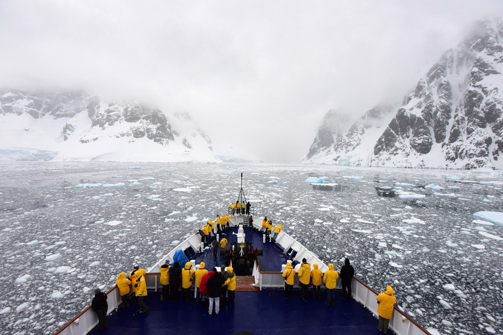 Passengers gather on deck to appreciate the icy waters of the Lemaire Channel on an Antarctic expedition.