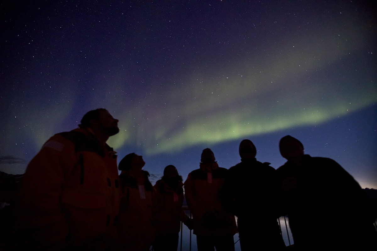 Quark Expeditions Passengers admire the northern lights from the deck of the ship. Photo by Acacia Johnson