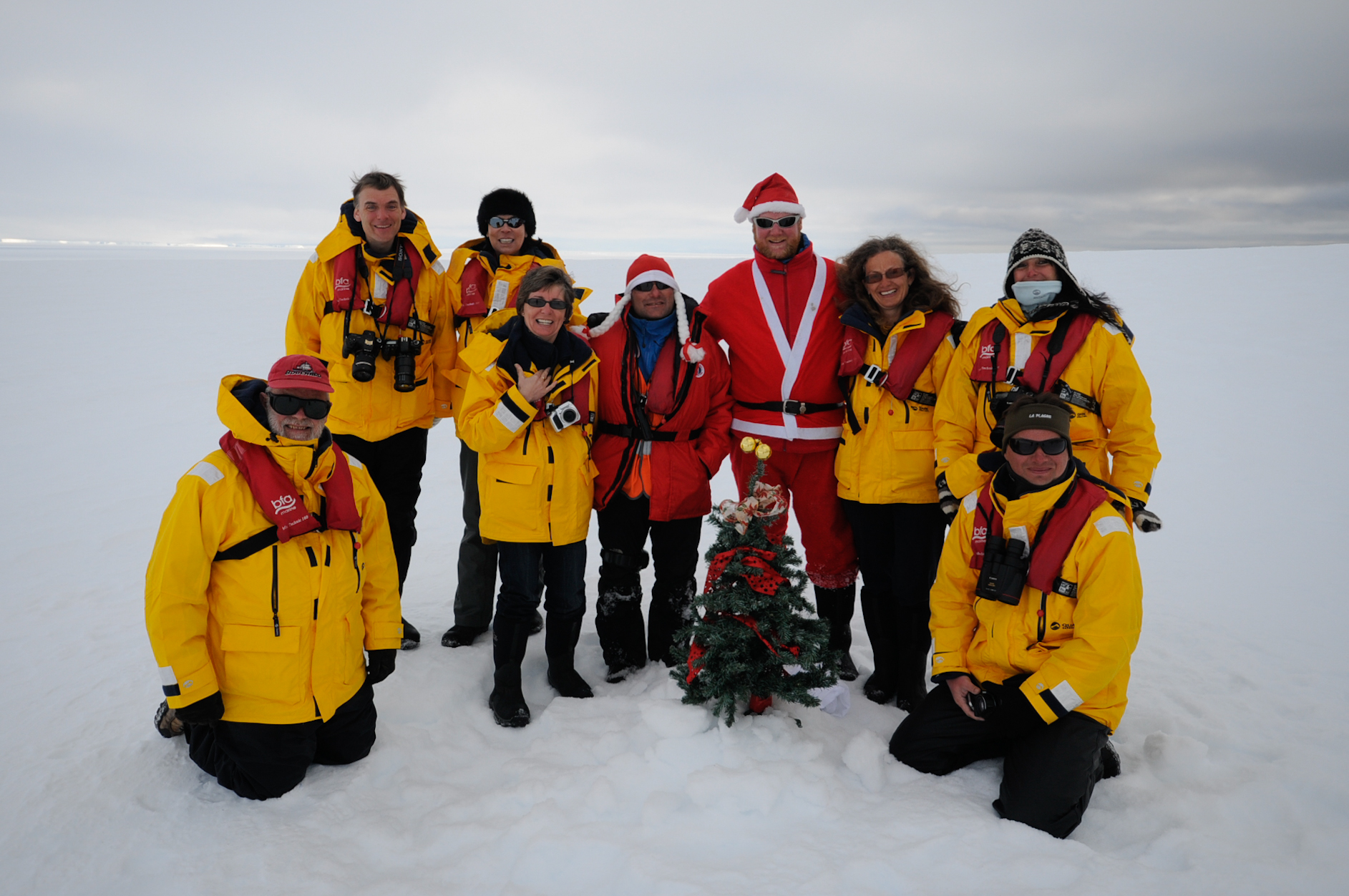 Quark Passengers pose with a Christmas tree in Antarctica