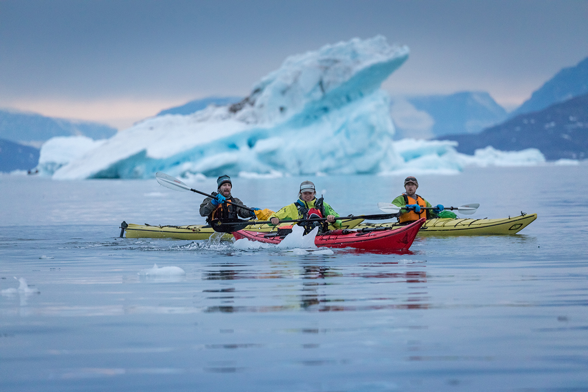 Kayakers paddling through sea ice in the evening. Photo by Acacia Johnson