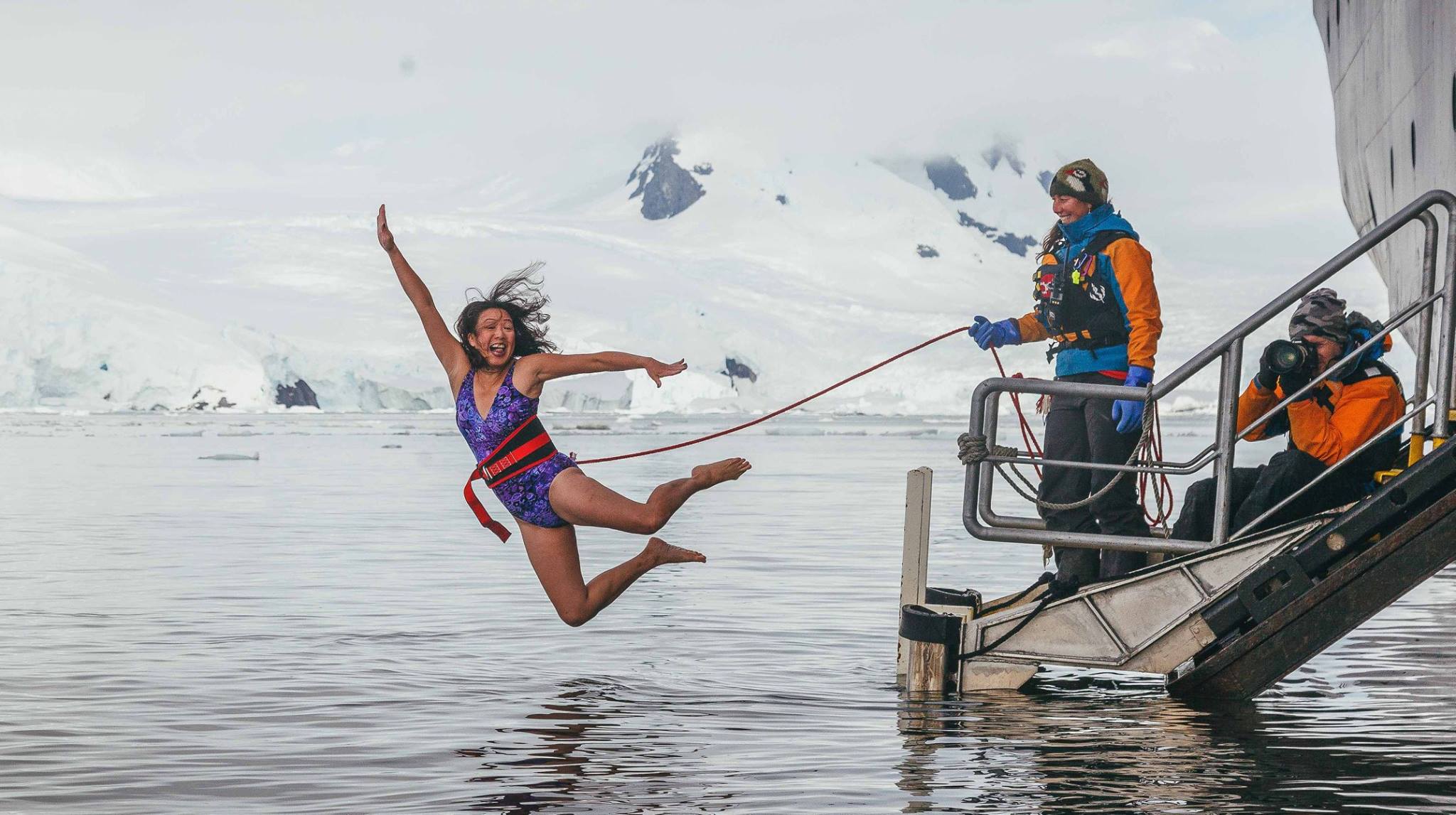May Lee soars off the gangplank into an icy Antarctic bay during the Polar Plunge, a popular rite of passage on polar expeditions