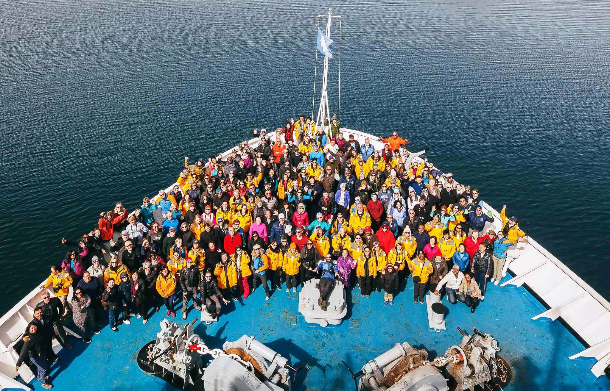 Passengers, crew and expedition team get together for a celebratory group shot on the bow of Ocean Endeavour at the end of their holiday season expedition to Antarctica.
