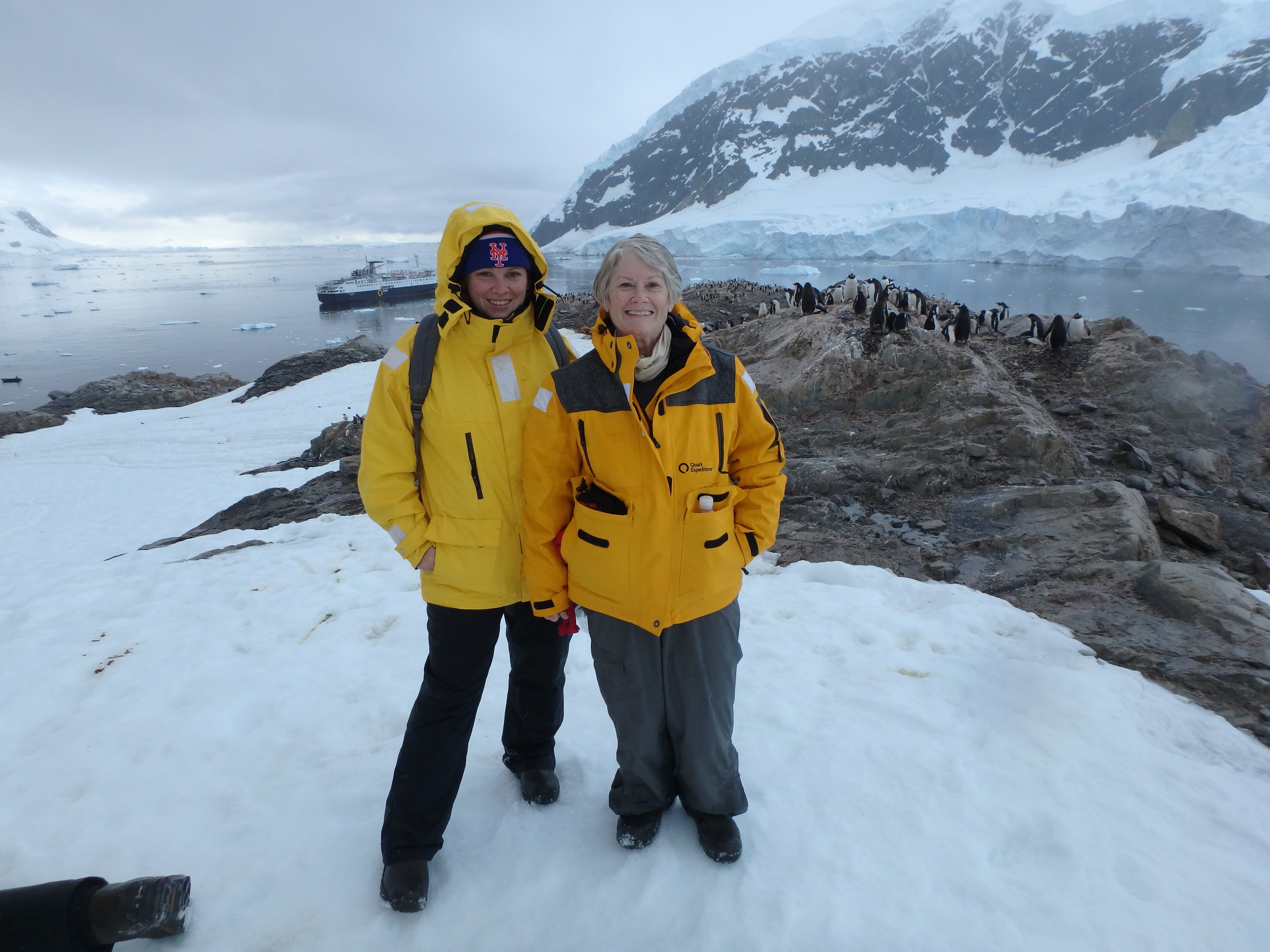 Katrina and her aunt pose with Adelie penguins in Antarctica