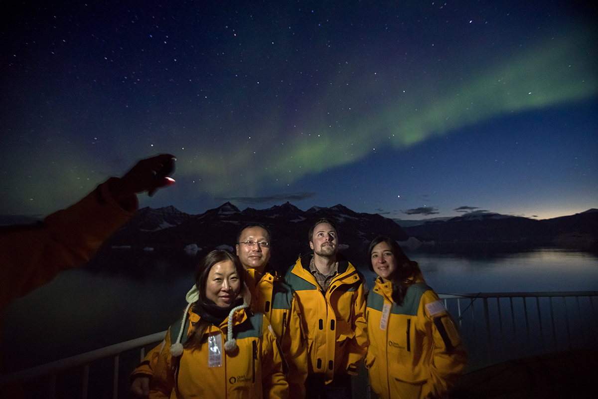 A group photo with the Northern Lights in the background. Photo by Acacia Johnson