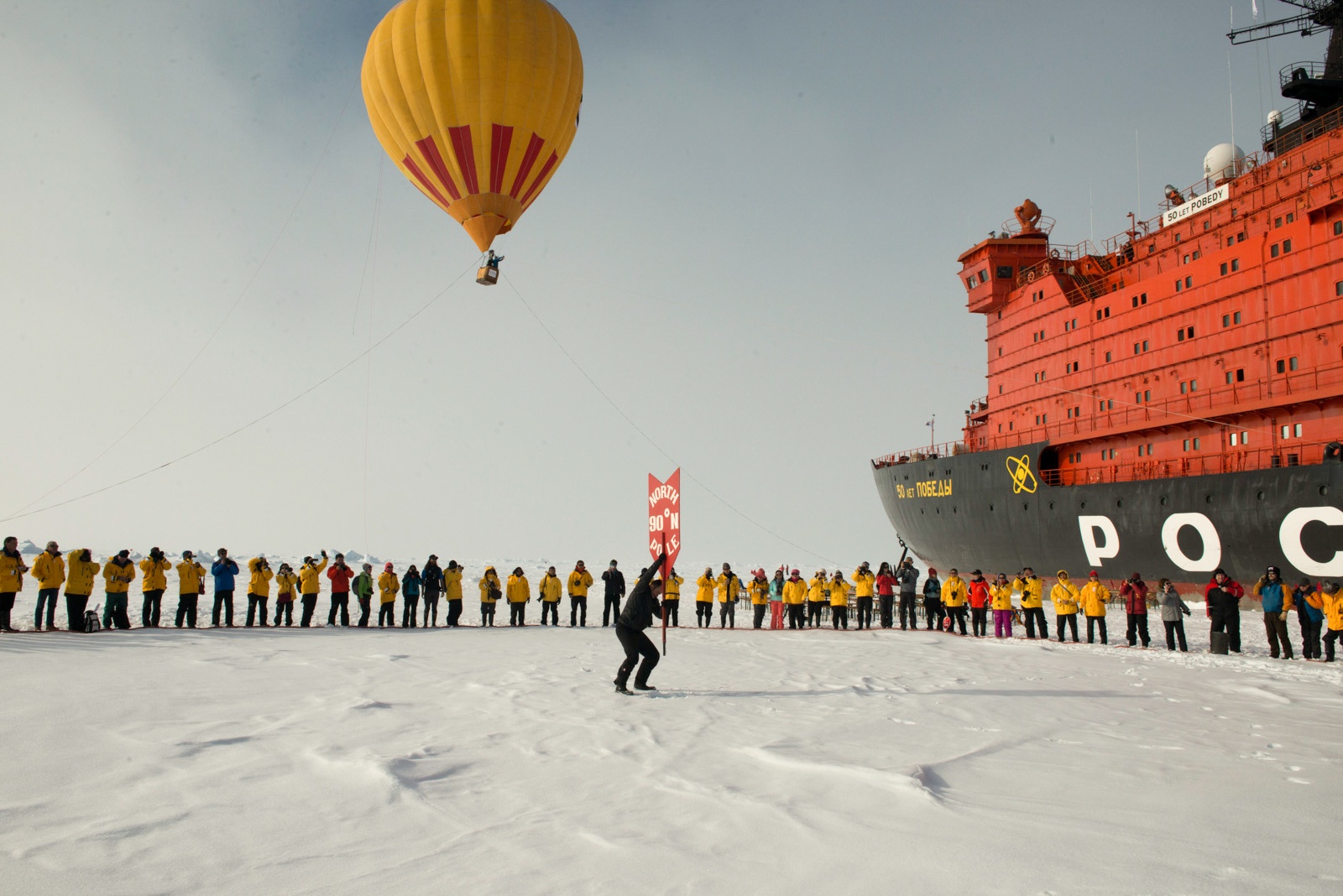 Passengers celebrate reaching the North Pole in a gathering on the thick, multi-year Arctic sea ice.