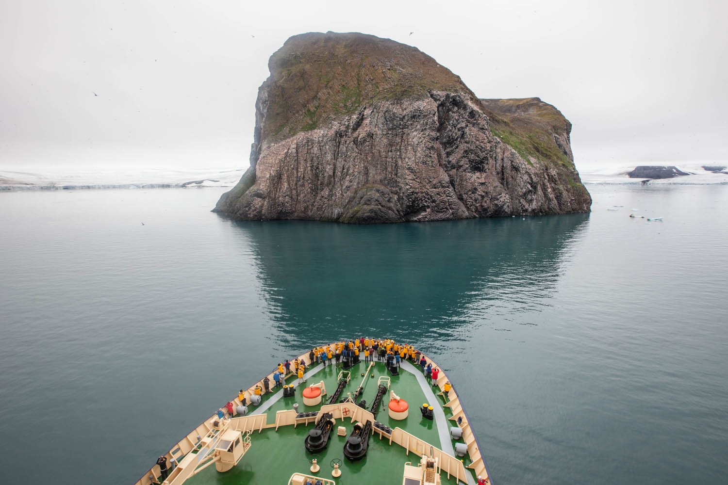 Guests traveling with Quark Expeditions guests on the deck of the ship on a voyage through the remote regions of the Russian Arctic, Franz Josef Land.