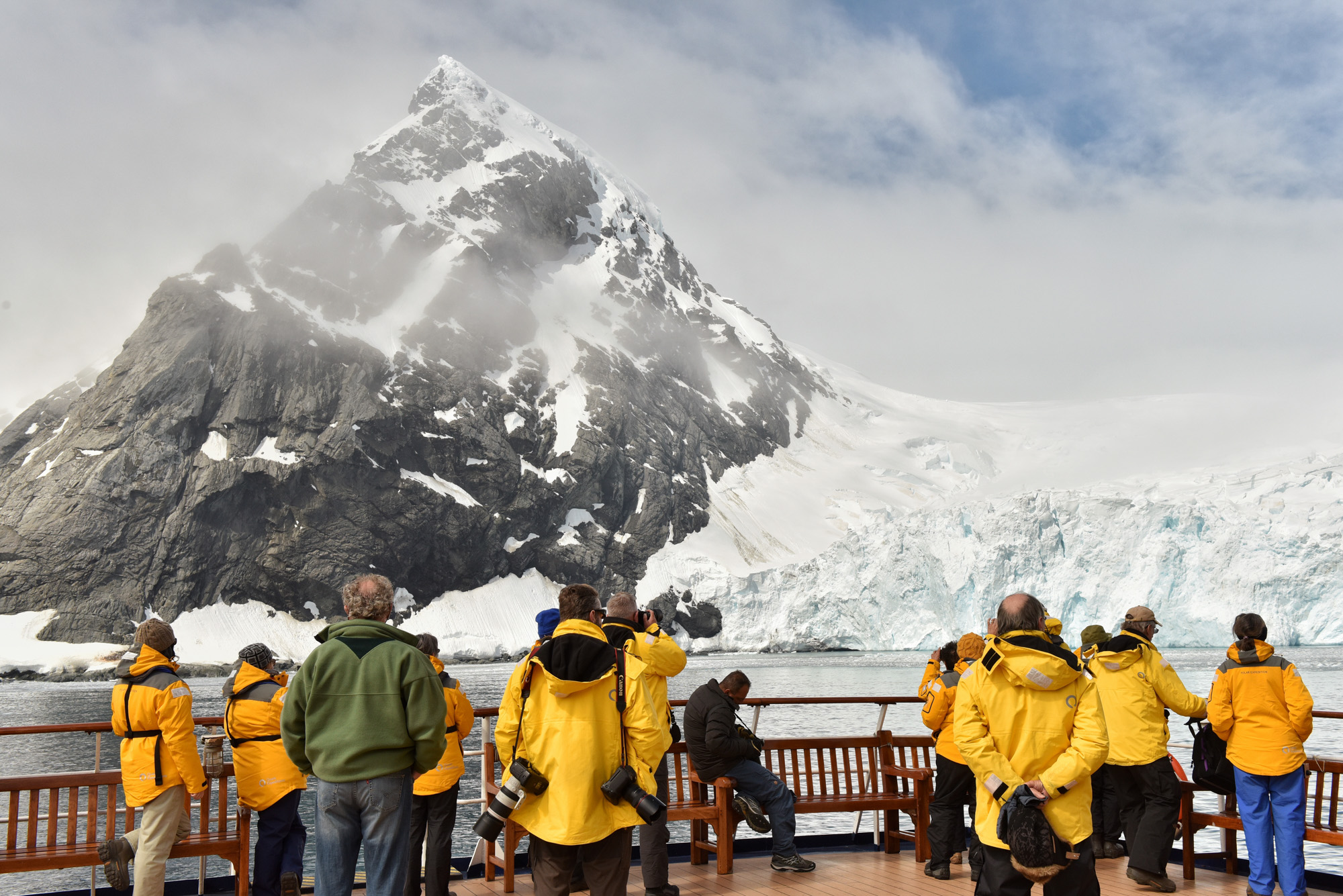 Passengers marvel at the sheer scale of Point Wild, an important Antarctic historic site.