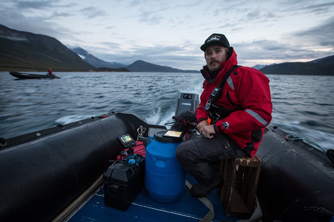 Quark Expeditions team member Alex McNeil on a Zodiac cruise in Tasermiut Fjord, South Greenland. 