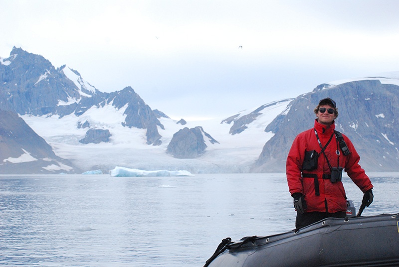 Operations Manager Jake driving a zodiac in the Arctic