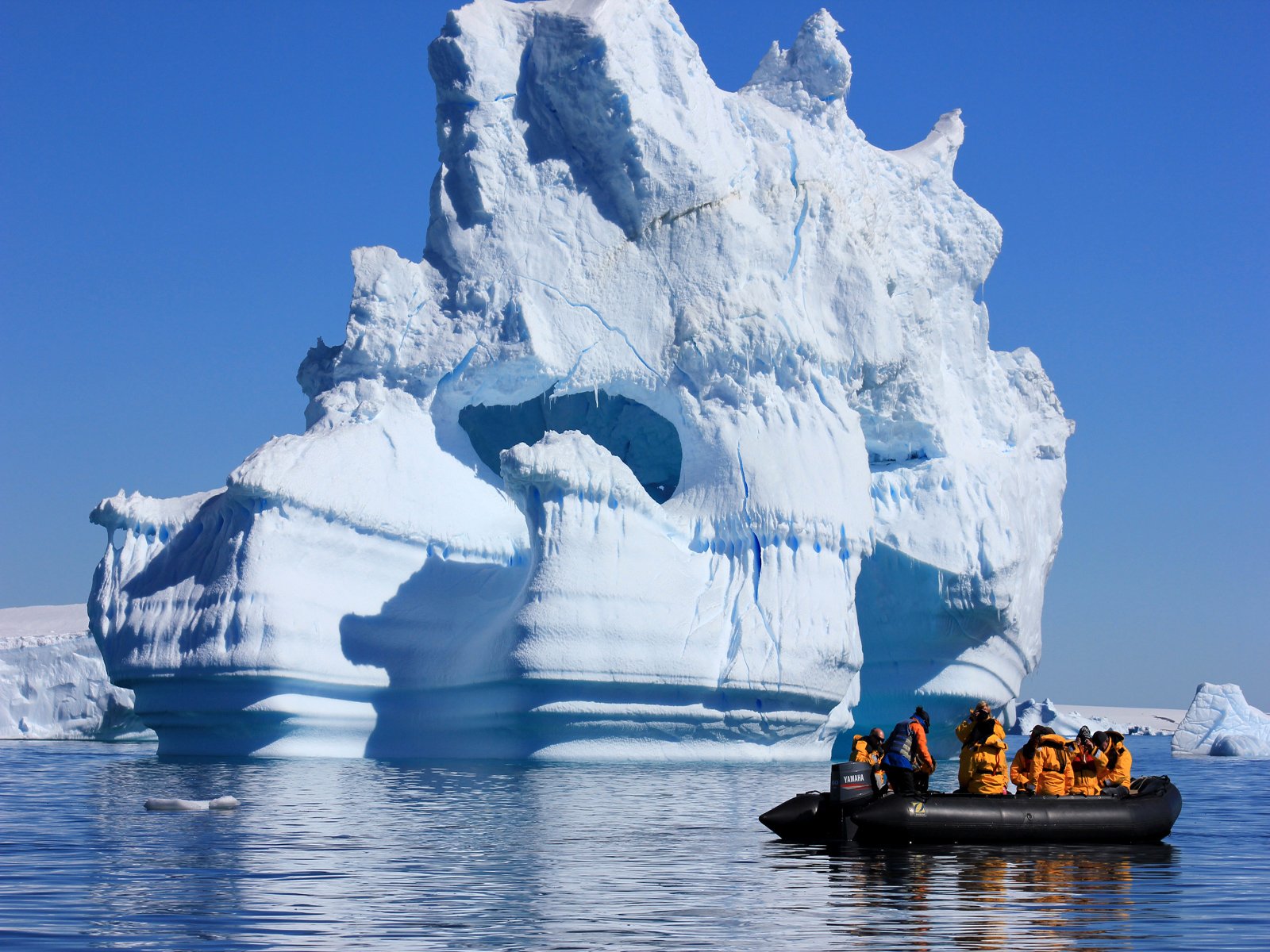 Quark passengers drift by a giant iceberg on a Zodiac excursion in Antarctica.