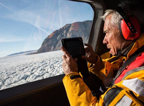 Passenger taking a photo of Arctic landscape from Helicopter